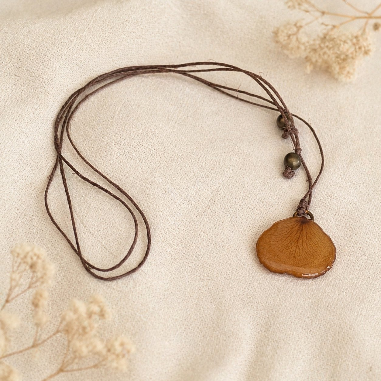 Collier artisanal avec un pétale de rose sous résine